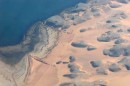 lake nasser from air3 * Aerial view of Lake Nasser shore showing the low hills in the desert. Cropland areas are faintly seen near the center (furrowed ground). * 432 x 289 * (42KB)