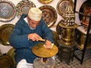 Metalworker * A metal worker, patiently tapping away on the metal plate, slowly forming one of the many intricate designs learned by heart.  No pattern is used here, simply years of training. * 576 x 431 * (133KB)