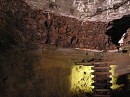 ore * A thick layer of ore visible in this cavern.  When they tried to open this up, several miscalculations ended up with the whole area collapsing.  However, the horizontal deposit of ore is clearly visible near the top of the photo (dark reddish area). * 432 x 323 * (61KB)